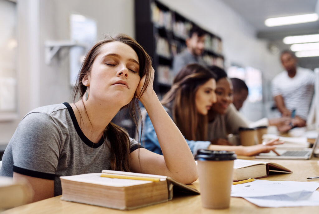 A women is sleeping in frond of books